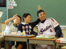 授業の後は教室で一緒に給食を食べるなどしてふれ合いました。最初は緊張気味だった児童たちもだんだんと打ち解け、度会氏の周りにはサインを求める子どもたちでいっぱいに! 