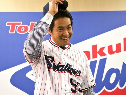 笑顔でユニホームに袖を通す